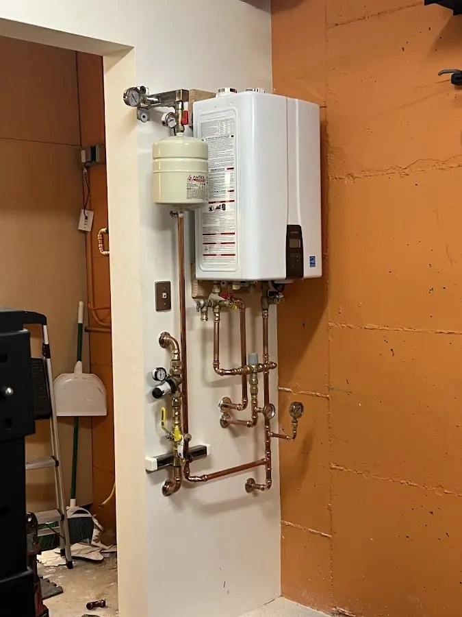 Plumbing technician inspecting water heater connections in Lanham